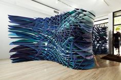 a woman standing in front of a large blue sculpture on top of a hard wood floor