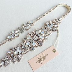 the bridal belt is adorned with swaro - cut crystal stones and pearls, along with a name tag