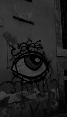 graffiti on the side of a building with an eye drawn in it's center