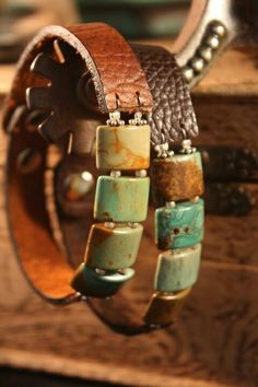 bracelets with turquoise and brown beads are hanging from a wooden box