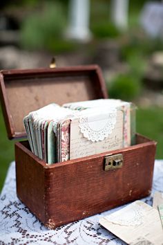 an old wooden box filled with lots of papers on top of a blue table cloth