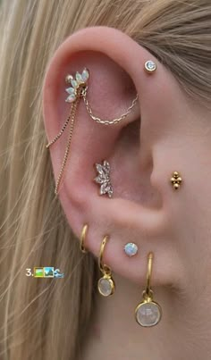 a woman wearing three different types of ear piercings