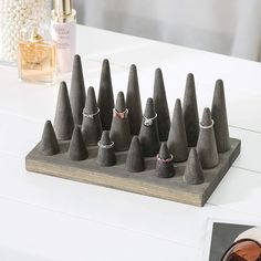 a set of seven rings sits on top of a wooden stand next to some pearls