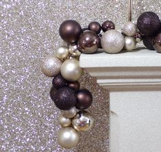 a close up of a wreath made out of ornaments on a wall with glitter behind it