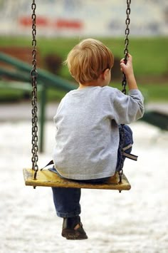 a little boy that is sitting on a swing