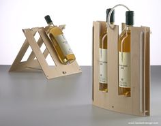 two bottles of wine in wooden cases on a white surface with an easel holding them