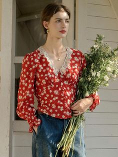 This product is a Floral V-Neck Red Blouse that beautifully combines vintage charm with contemporary fashion trends. It is designed with a flattering v-neckline framed by delicate lace, highlighting the décolletage area. The blouse’s long sleeves and relaxed fit contribute to its versatile nature, suitable for various occasions. - This blouse features a delightful floral pattern that exudes a sense of playful sophistication.- The lace detailing along the v-neck adds a refined touch, enhancing the overall design of the garment.- It's constructed with a lightweight fabric that offers both comfort and breathability.- Elasticated cuffs create a gentle puff effect on the sleeves, adding to the blouse's romantic and whimsical appeal. Feminine V-neck Top With Lace Collar, Elegant Red V-neck Blouse, Elegant V-neck Blouse With Lace Patchwork, Feminine V-neck Blouse With Lace Patchwork, Feminine Red V-neck Tops, Elegant Lace Blouse With Floral Print, Feminine V-neck Tops With Lace Collar, Chic Red V-neck Blouse, V-neck Lace Blouse With Patchwork