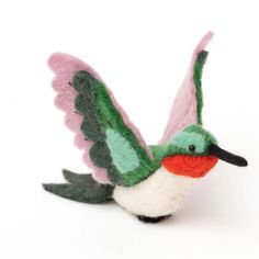 a small stuffed bird with green, pink and white feathers on it's wings