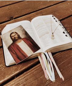 an open bible with a photo of jesus on it and a tassel hanging from the book