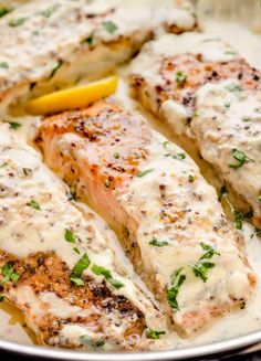 salmon fillets with lemon sauce and herbs in a pan on a stovetop, ready to be eaten