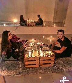 two people are sitting on the floor with candles