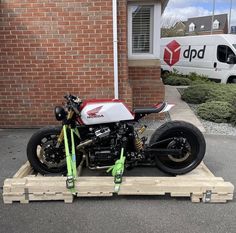 a white and red motorcycle parked on top of a wooden pallet