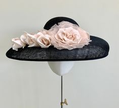 "A classically elegant navy blue wide brim straw hat, with a beautiful floral twist. This headpiece features a beautiful shell oyster pink duchesse satin pleated band around the crown. To complement the band, a matching oyster pink satin and organza rose sits in the centre, with a gorgeous cluster of five handmade silk rose buds trailing  along the brim. This hat measures 44cm from side to side, and 37cm front to back, and is made to a standard 22\" diameter. If you require a smaller fit, I am a Elegant Navy Wide Brim Hat, Elegant Navy Hats With Curved Brim, Elegant Navy Hat With Curved Brim, Elegant Hats With Handmade Flowers For Garden Party, Elegant Hats With Handmade Flowers And Curved Brim, Elegant Handmade Flower Hats For Garden Party, Elegant Summer Hats With Handmade Flowers, Elegant Summer Hat With Handmade Flowers, Elegant Navy Hat For Evening