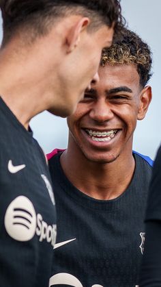 two young men are laughing together at the same time