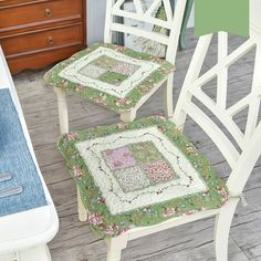 two white chairs sitting on top of a wooden floor next to a table and chair