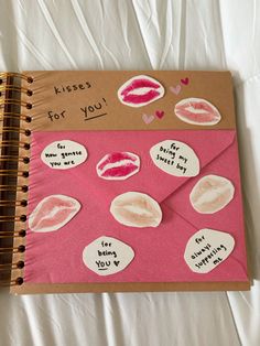 a pink notebook with stickers on it and an envelope that says kisses for you