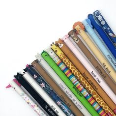 a group of different colored pencils sitting next to each other on a white surface