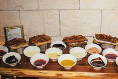 a wooden table topped with bowls filled with different types of food and dipping sauces