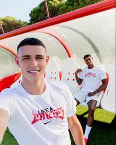 two young men are posing for a photo in front of some fake soccer goalies