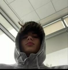 a young man wearing a hoodie taking a selfie