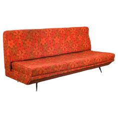 an orange and brown couch sitting on top of a white floor