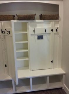 an empty room with white cabinets and baskets on the top shelf, along with two wicker bins