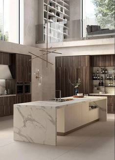 a large kitchen with marble counter tops and wooden cabinetry, along with an island in the middle