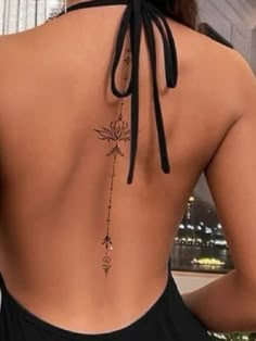 the back of a woman's body with tattoos on it, and an arrow