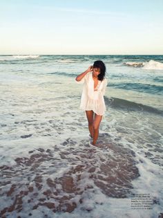 a woman standing in the water at the beach