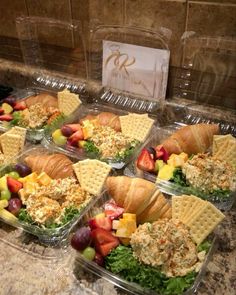 four plastic containers filled with food on top of a marble counter next to a tile backsplash