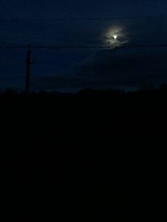 the full moon is shining brightly in the dark sky above some power lines and telephone poles