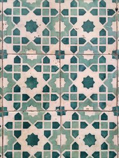 an old tiled wall with green and white tiles