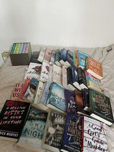 a bed topped with lots of books on top of it's side next to each other