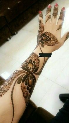 a woman's hand with henna tattoos on it