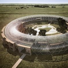 an aerial view of a circular building in the middle of a field