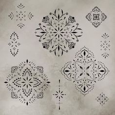 some black and white designs on a gray wall with water droplets in the middle,