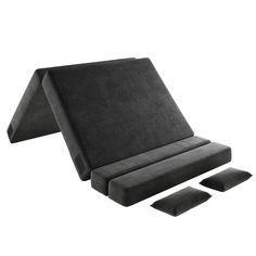 a black couch with three pillows on the bottom and one in the middle, sitting next to each other