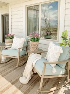 two chairs and a table on a porch