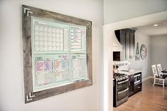 a kitchen wall with a calendar hanging on it's side next to a dining room table