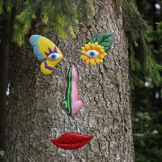 a tree with three colorful faces painted on it