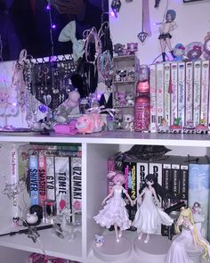 a shelf filled with lots of dolls and books