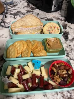 two plastic containers filled with food on top of a marble countertop next to a toaster oven