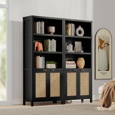 a black bookcase with wicker baskets in front of it and a window behind it