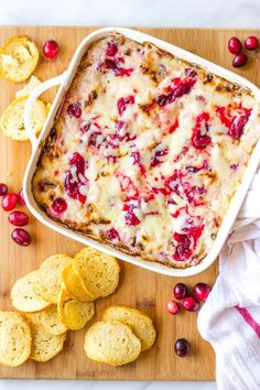 a casserole dish with cranberry sauce and crackers on the side