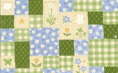 a green and blue patchwork quilt with flowers