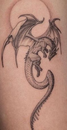 a black and white dragon tattoo on the side of a woman's thigh,