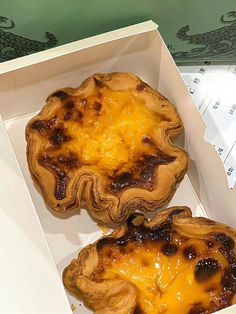 two pies in a box with cheese on top