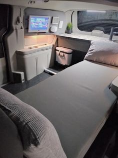 the inside of an airplane with a bed and television