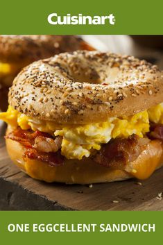 an egg and bacon bagel sandwich on a wooden board with the words cusinart