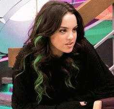 a woman with green hair sitting at a table